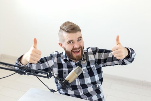 Radio host streamer and blogger concept - Man gesturing thum up over white background, host at radio station
