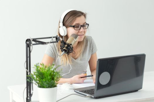 blogger, streamer and broadcasting concept - young woman DJ working on the radio.