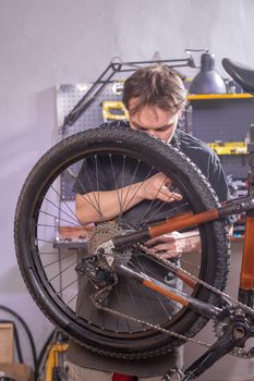 Service, repair, bike and people concept - Mechanic repairing a mountain bike in a workshop.