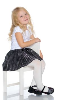 Little girl is sitting on a stool