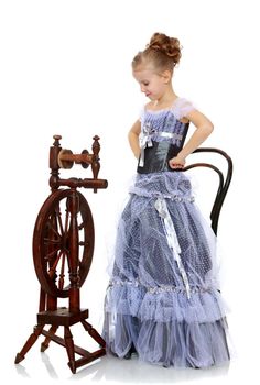 Little girl sitting at a spinning wheel.