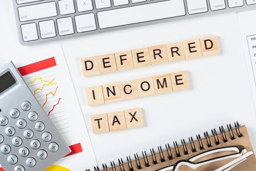 Deferred income tax concept with letters on cubes