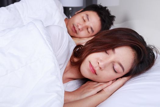 couple sleeping on a comfortable bed in bedroom at home