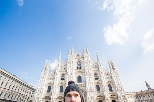 Italy, excursion and travel concept - funny guy taking selfie in front of cathedral Duomo in Milan