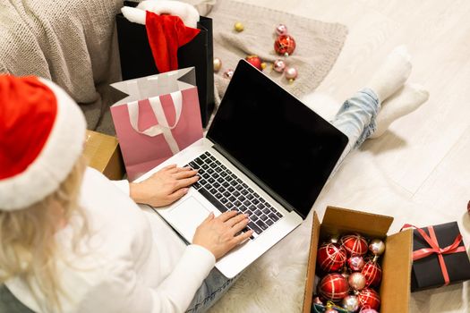 Young woman ordering Christmas gifts online Christmastime decorations