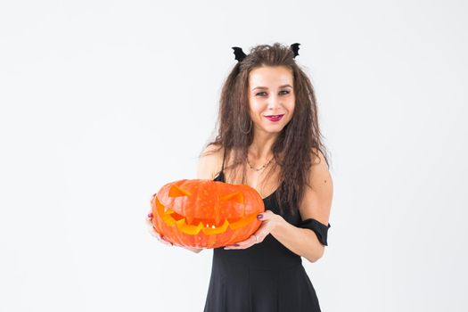 Halloween and masquerade concept - Beautiful young woman posing with Pumpkin Jack-o'-lantern