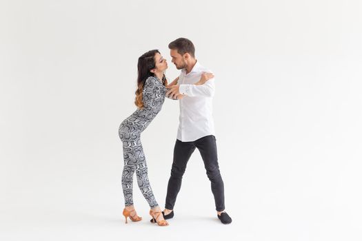 Skillful dancers performing in the white background with copy space. Sensual couple performing an artistic and emotional contemporary dance