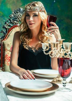young blond woman wearing crown in fairy luxury interior with empty antique frames total wealth concept