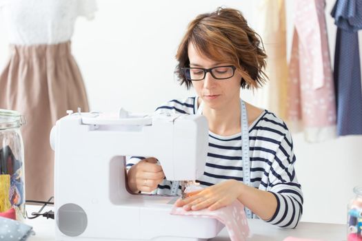 clothing designer, seamstress, people concept - clothing designer working in her studio
