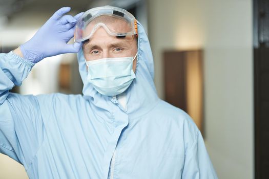 Man wearing a protective mask, gloves and suit before disinfection
