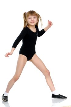 A little girl does gymnastic exercises.