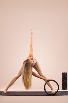Indoor Yoga Classes. Sports recreation. Beautiful young woman in asana pose. Individual sports. Nude sportswear.