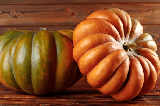 Colorful pumpkins on brown wooden background front view