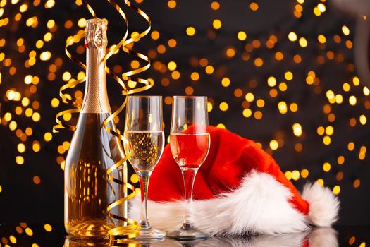 Champagne and Santa Claus hat on blurred garland background