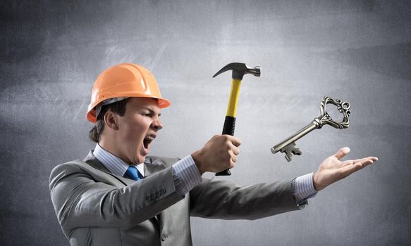 Businessman going to crash with hammer steel key