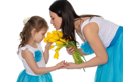 Mother and daughter smelling yellow tulips.