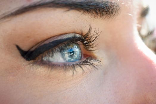 Close-up of young woman's blue eyes with long eyelashes