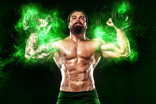 Athlete in green energy lights. Muscular young fitness sports man bodybuilder workout with dumbbell in fitness gym