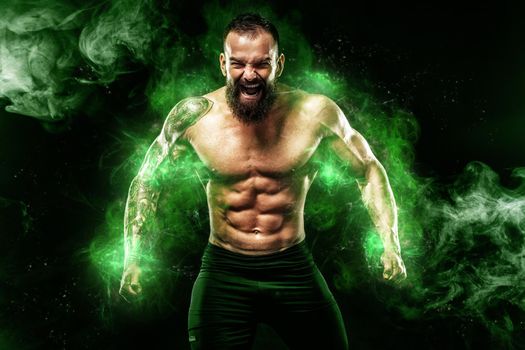 Athlete in green energy lights. Sportsman muay thai boxer celebrating victory on black background with smoke. Copy Space. Sport concept.