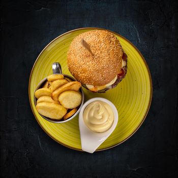 Burger served with potatoes and mayonnaise
