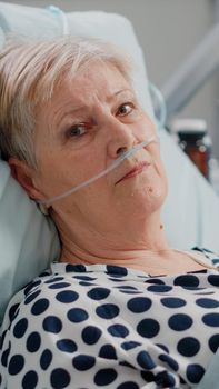 Portrait of elder woman with nasal oxygen tube laying in bed