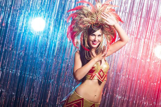 Carnival, belly dance and holiday concept - Beautiful female samba dancer wearing gold costume and smiling