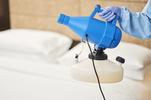 Worker using effective disinfectant for hotel premises