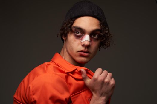 man with broken nose bruises under eyes orange shirt crime