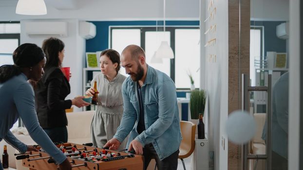 Man playing foosball game at table with woman and losing