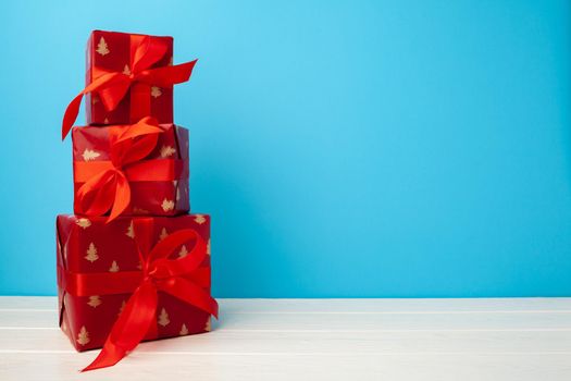 Several stacked Christmas gifts in festive wrapping