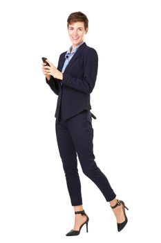 Full body businesswoman in formal suit smiling with mobile phone against isolated white background