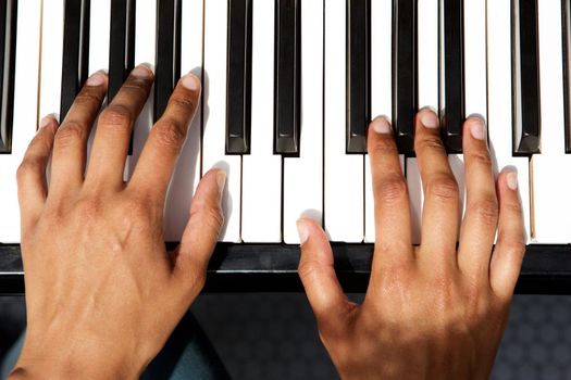 top view of female hands playing piano