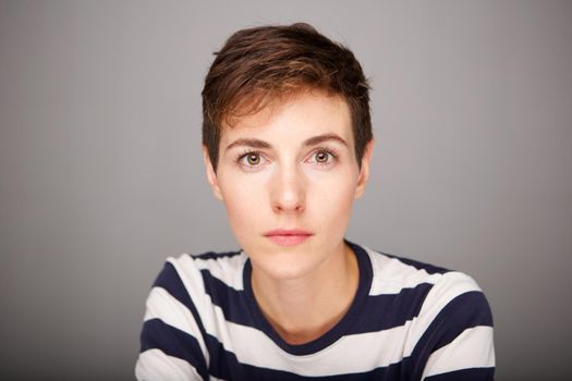 Close up serious young woman with short hair staring