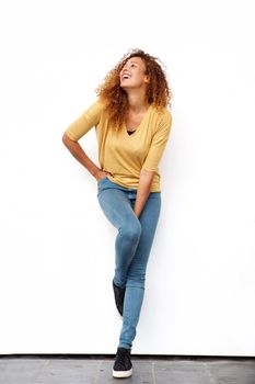 Full body young woman laughing against white wall