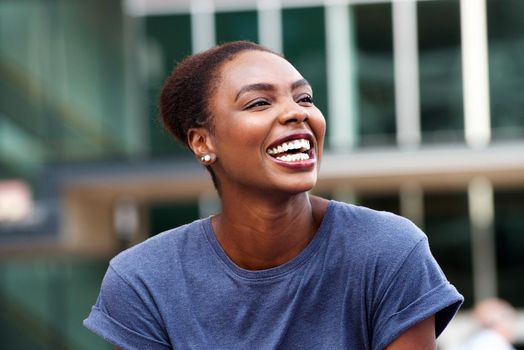 Close up attractive young african american woman laughing outdoors