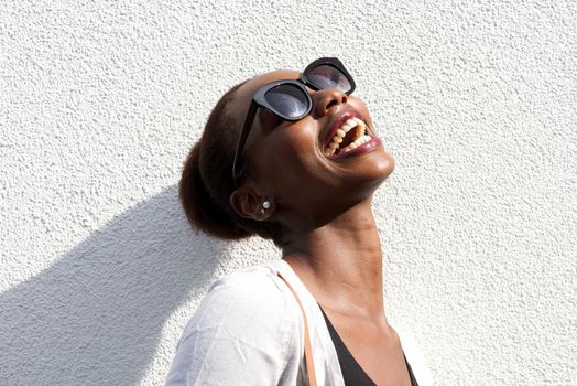 Close up fashion portrait of happy young black woman with sunglasses