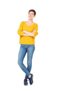 Full length happy young woman standing with arms crossed against isolated white background