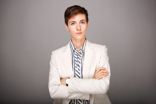 serious young businesswoman against gray background