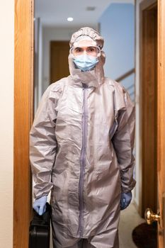 Doctor in PPE Personal Protective Equipment coming into the house