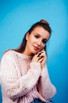 young pretty modern hipster girl posing emotional happy on blue background, lifestyle people concept close up