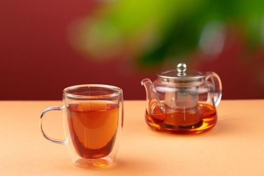 Glass teapot and cup with black tea