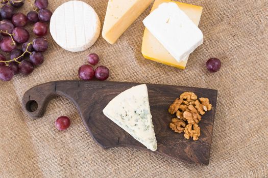Cheese party table, perfect holiday appetizer with nut on rustic wooden board