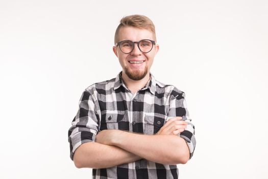 People, nerd and education concept - Smiling handsome student man in plaid shirt, crossed arms, over white background