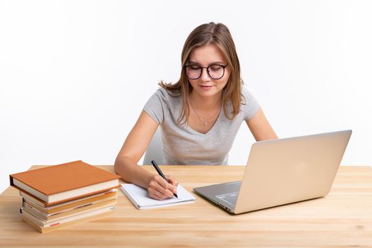 Study, education and people concept - young female nerd is learning exercises using laptop