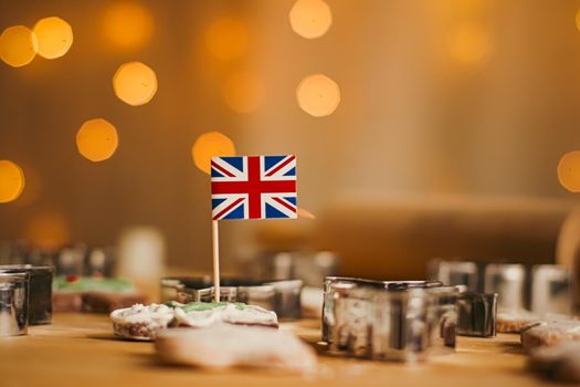 British holiday and Christmas baking concept. Union Jack flag of Great Britain and gingerbread men biscuits in the kitchen in England
