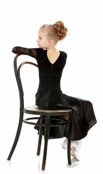 Slender little dancer posing near the old Vienna chair.