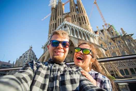 BARCELONA, SPAIN - FEBRUARY 7, 2018: Happy tourists photographing in front of the famous Sagrada Familia roman catholic church in Barcelona, architect Antoni Gaudi