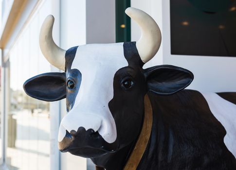 Close up of a cow head statue in front of shop