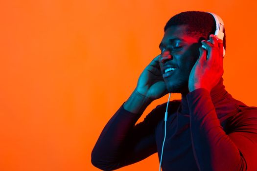 Neon portrait of handsome african american man in headphones. Listening to music.