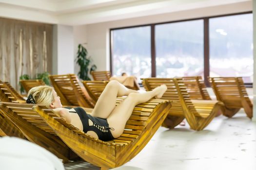 Beautiful woman relaxing on lounger in hotel, girl on sun lounger in spa